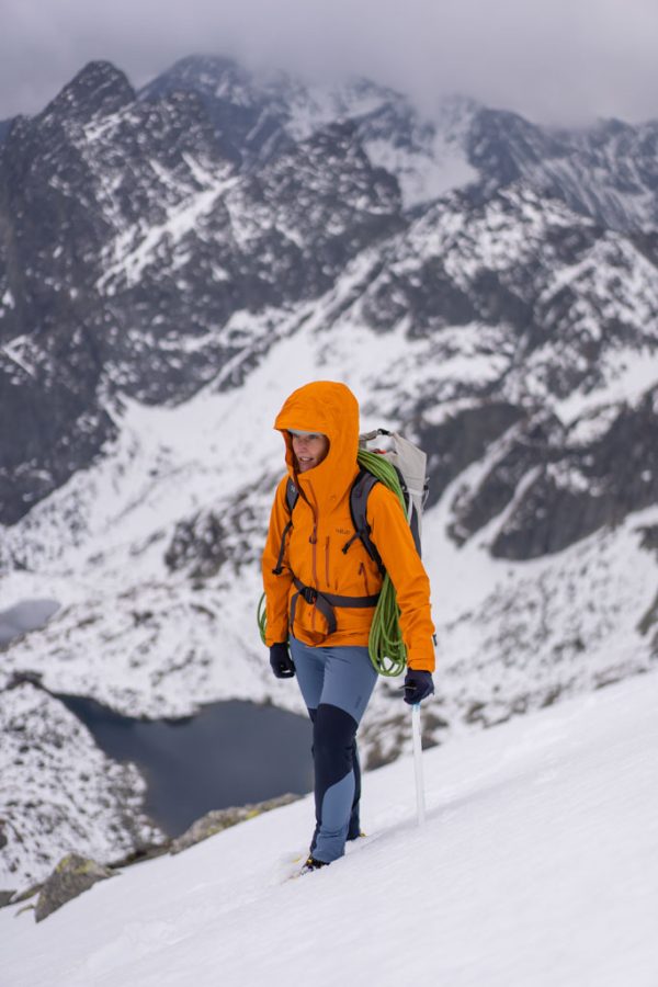 Dámská nepromokavá bunda Rab Firewall Jacket Marmalade na horolezkyni v horách