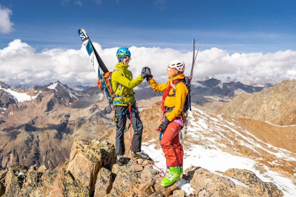 Dámská bunda Rab Khroma Cirque a pánská bunda Rab Borealis na horském hřebeni při skialpinismu