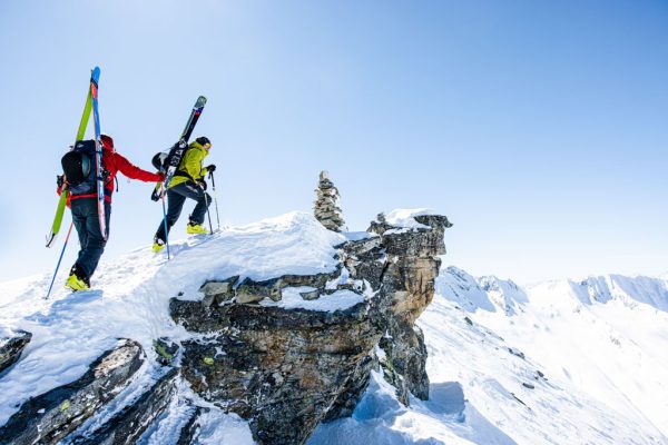 Skialpová bunda Rab Khroma Cirque při skialpovém výstupu na skalním útesu