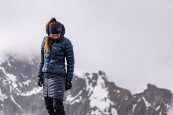 Modrá dámská bunda péřová bunda Rab Mythic Alpine na vrcholku hor