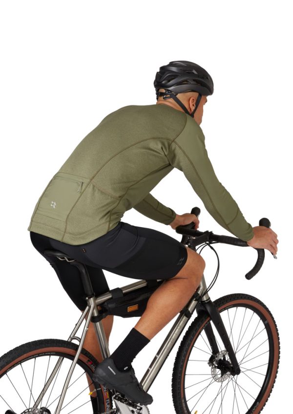 Zadní kapsa Ultimátní střední vrstvy Rab Cinder Ridgeline ze speciální cyklistické kolekce Rab Cinder na postavě na kole v cyklistickém posedu z boku